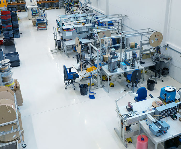 Ylhäältä päin otettu kuva työtilasta, jossa näkyy useita työpisteitä.