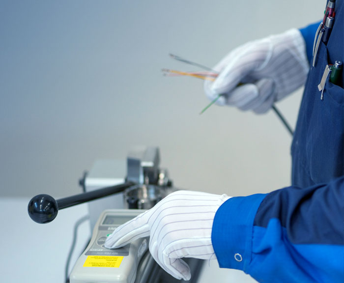 Vetolujuusmittaus, kuvassa näkyy laite, nippu johtoja sekä työntekijän kädet.