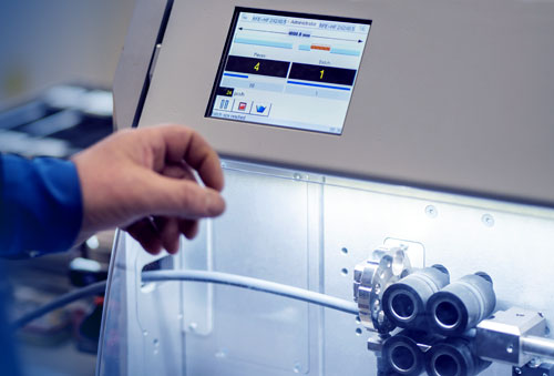 Työntekijä käyttää kaapelinkatkontalaitetta.